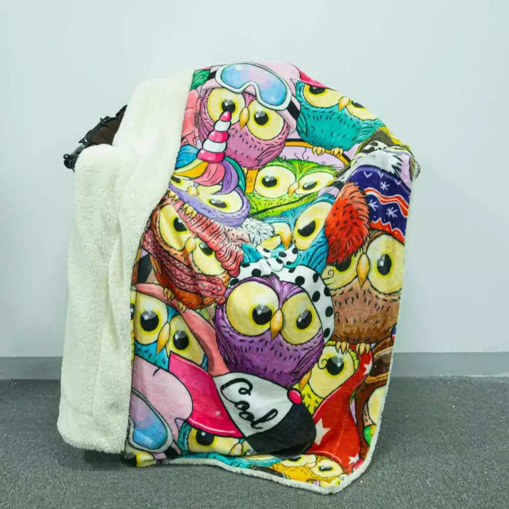 Orange personalized sherpa throw blanket with purple smiley faces on sofa